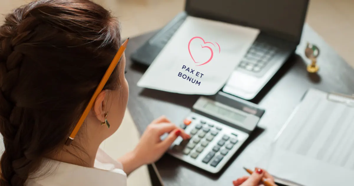 Kobieta rozliczająca podatek przy laptopie, kalkulator i dokumenty na biurku